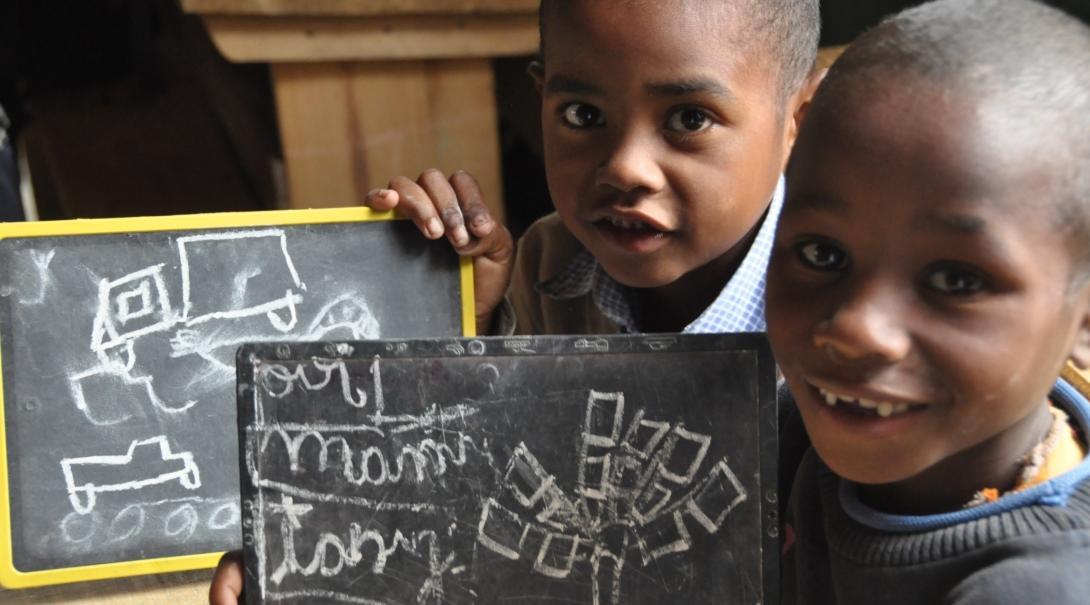 Young students show their work on mini blackboards at one of our Projects Abroad teaching placements in Madagascar Smiling students show their answers to an exercise given to them by a volunteer teaching English in Madagascar